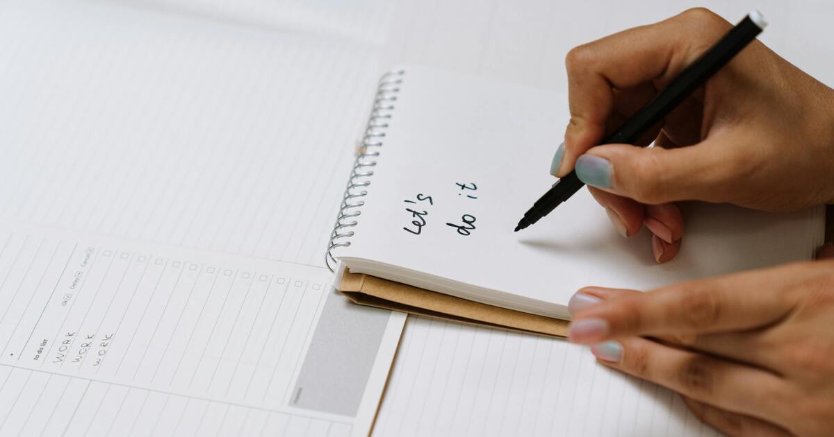 A person checking off daily habits in a planner, representing consistency and routine